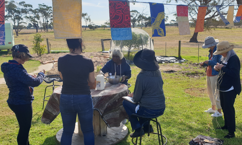 Tiwi Elder making damper with women weaving
